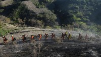 Petugas memadam kebakaran berbaris menembus hutan Whittier, California yang terbakar, Kamis, (10/2/2022). 