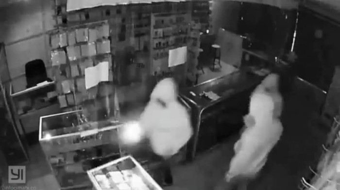 Tiga pria berjaket hoodie tengah membobol sebuah konter handphone di Cimahi