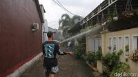 Warga berkeliling kompleks untuk menyemprotkan disinfektan.