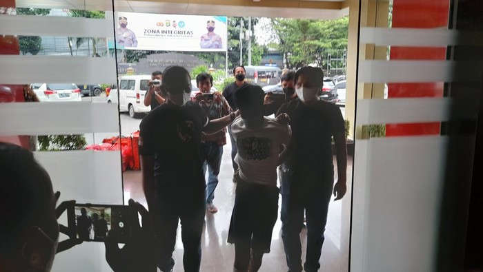 Polisi saat membawa salah satu terduga pelaku pembunuhan di TPU Kober (Marteen-detikcom)
