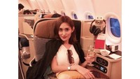 Terbang menggubakan business class, Karra tunjukkan pose cantiknya saat menikmati champagne. Foto: Instagram Karra Syam