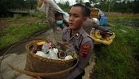 Warga dibantu petugas kepolisian mengevakuasi barang-barang berharga dari rumahnya yang terdampak bencana tanah bergerak di Kabupaten Tegal.
