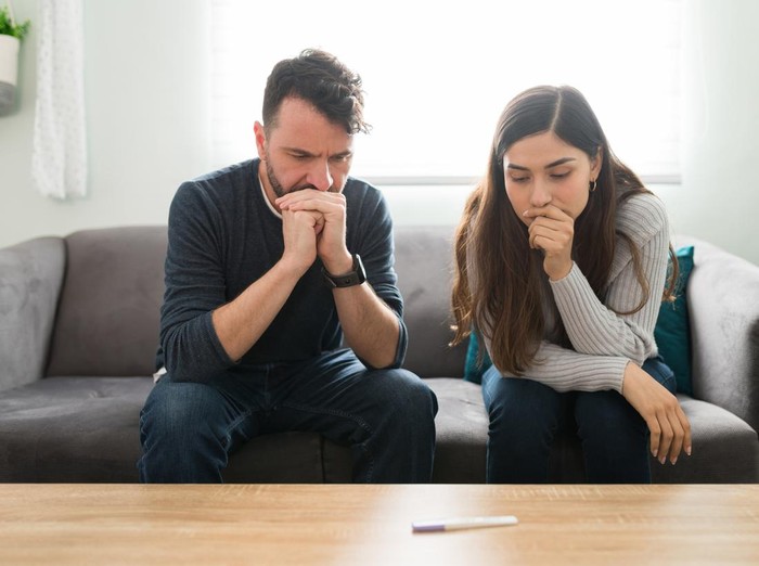 1311091082 Attractive couple feeling scared and anxious while waiting for the positive or negative results of a home pregnancy test