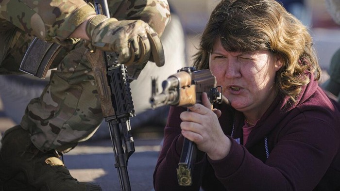 A woman aims a weapon during a basic combat training for civilians, organized by the Special Forces Unit Azov, of Ukraines National Guard, in Mariupol, Donetsk region, eastern Ukraine, Sunday, Feb. 13, 2022. The United States are evacuating almost all of the staff from its embassy in Kyiv as Western intelligence officials warn that a Russian invasion of Ukraine is increasingly imminent. (AP Photo/Vadim Ghirda)