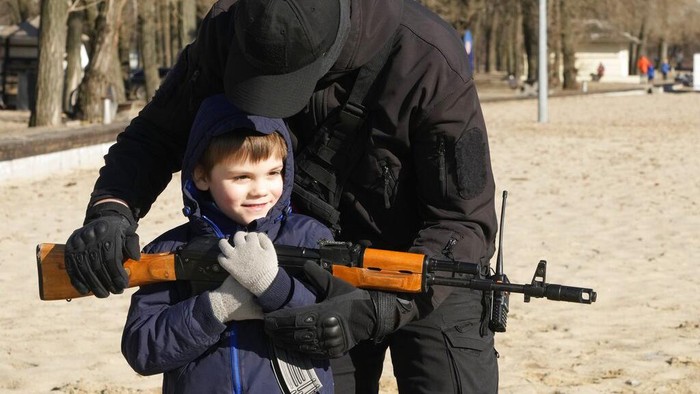 A woman aims a weapon during a basic combat training for civilians, organized by the Special Forces Unit Azov, of Ukraine's National Guard, in Mariupol, Donetsk region, eastern Ukraine, Sunday, Feb. 13, 2022. The United States are evacuating almost all of the staff from its embassy in Kyiv as Western intelligence officials warn that a Russian invasion of Ukraine is increasingly imminent. (AP Photo/Vadim Ghirda)