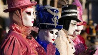 Orang-orang memakai topeng di Lapangan St. Mark, selama Karnaval Venesia, di Venesia, Italia, Minggu (13/2/2022).  