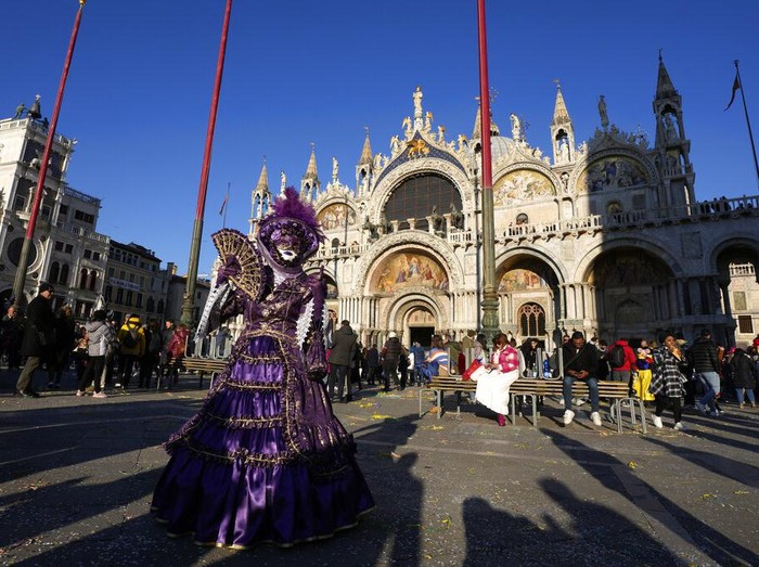 Boats sail during the water parade, part of the Venice Carnival, in Venice, Italy, Sunday, Feb. 13, 2022. Two years after the pandemic shut down celebrations, the Venice carnival in the historical lagoon city is back, attracting people from around the world. (AP Photo/Antonio Calanni)