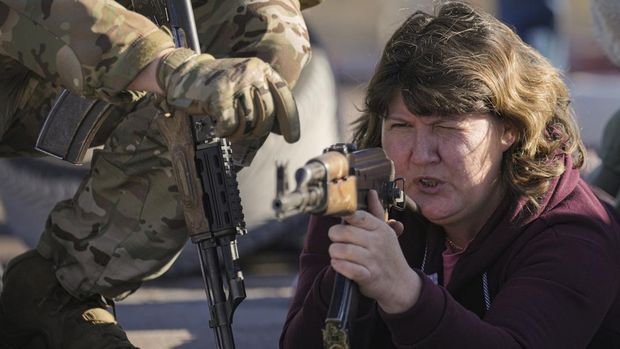 Seorang wanita memegang senjata selama pelatihan tempur dasar untuk warga sipil yang diselenggarakan oleh Unit Pasukan Khusus Azov, dari Garda Nasional Ukraina, di Mariupol, wilayah Donetsk, Ukraina timur, Minggu (13/2/2022). Amerika Serikat mengevakuasi hampir semua dari staf kedutaan besarnya di Kyiv ketika pejabat intelijen Barat memperingatkan bahwa invasi Rusia ke Ukraina semakin dekat. (AP Photo/Vadim Ghirda)