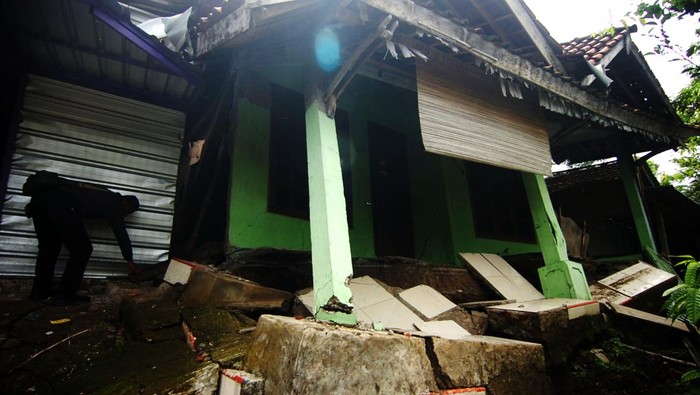 Dua warga duduk di dekat jalan desa yang terbelah akibat bencana tanah bergerak di Desa Dermasuci, Kabupaten Tegal, Jawa Tengah, Senin (14/2/2022). Menurut data pemerintah desa setempat, jumlah rumah yang rusak akibat bencana tanah bergerak bertambah dari 97 rumah menjadi 238 rumah dan mengakibatkan sejumlah akses jalan desa terputus. ANTARA FOTO/Oky Lukmansyah/pras.