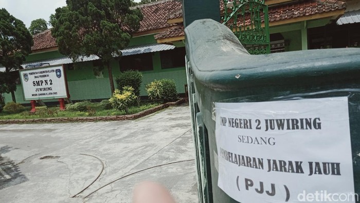 Pengumuman SMPN 2 Juwiring tutup dipasang di gerbang.
