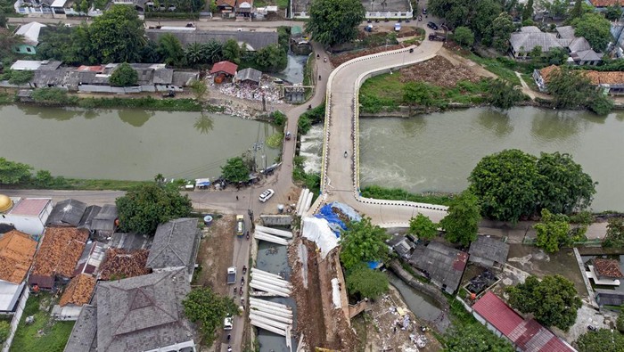 Foto udara suasana perbaikan proyek jembatan KW 6 yang ambles di Kelurahan Karangpawitan, Karawang, Jawa Barat, Minggu (13/2/2022). Proyek jembatan penghubung Kecamatan Karawang Barat dengan Rawamerta yang menghabiskan anggaran Rp10 miliar itu ambles usai dua pekan diresmikan dan menjalani perbaikan selama enam bulan. ANTARA FOTO/M Ibnu Chazar/foc.
