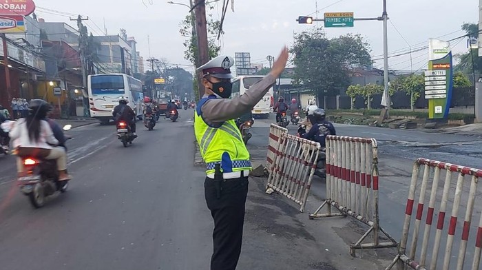 Polisi mengatur lalu lintas saat one way di Jalan Cikarang-Cibarusah