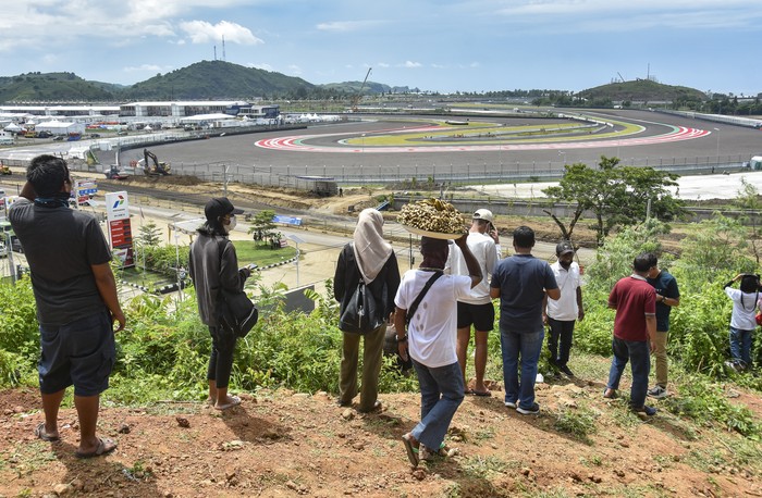 Sejumlah warga menonton sesi tes pramusim MotoGP 2022 dari atas bukit sekitar Pertamina Mandalika International Street Circuit di KEK Mandalika, Desa Kuta, Kecamatan Pujut, Praya, Lombok Tengah, NTB, Sabtu (12/2/2022). Warga antusias menyaksikan tes pramusim MotoGP 2022 yang diikuti 24 pembalap di sirkuit yang memiliki panjang 4,32 km dengan 17 tikungan itu. ANTARA FOTO/Ahmad Subaidi/pras.