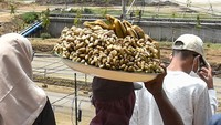 Pisang dan kacang rebus ia jajakan di tengah-tengah warga yang menonton tes MotoGP Mandalika dari bukit. Foto: ANTARA FOTO/AHMAD SUBAIDI