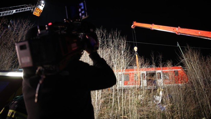 A cameraman films at the scene of the accident. One person was killed and more than ten injured in a collision between two commuter trains in the Munich district on Monday. There was a low double-digit number of injured, reported a spokesman for the Munich police headquarters.