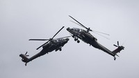 Sepasang helikopter serang Apache AH-64D Apache Angkatan Udara Republik Singapura (RSAF) melakukan manuver udara selama Singapore Airshow 2022 di Changi Exhibition Centre di Singapura.