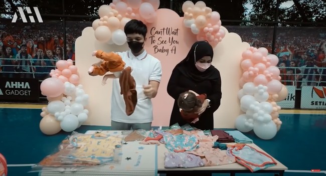 Momen kejutan itu pun semakin seru usai Atta Halilintar dan Aurel Hermansyah diajak untuk mencoba barang-barang tersebut menggunakan boneka bayi. Sebagai calon orangtua baru, keduanya tampak sudah cukup mahir untuk mengurus bayi. Foto: YouTube/AH