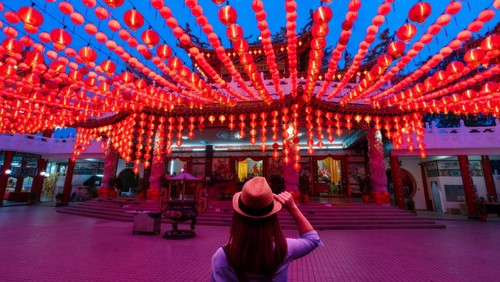 Young woman traveler traveling and looking red lanterns decorations in chinese temple name is Thean Hou Temple at Kuala Lumpur Malaysia. This place is famous during the celebration of Chinese New Year