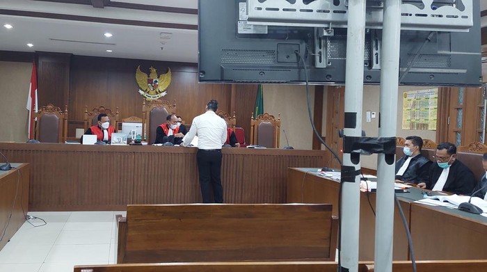 Jerinx serahkan foto disebut Adam Deni yang acungkan jari tengah ke foto Presiden Jokowi.