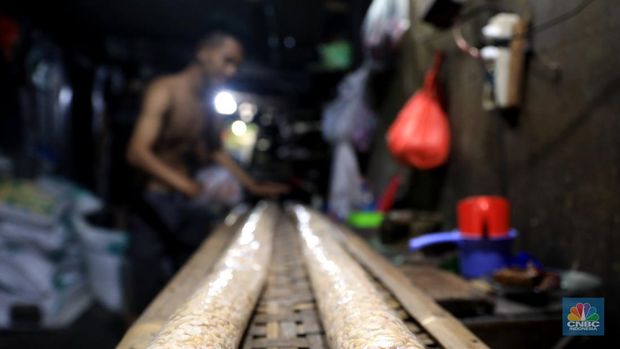 Perajin membuat tempe di industri rumahan skala kecil di Jalan Wahid, Ciputat, Tangerang Selatan, Selasa, (15/2/2022). Kenaikan biaya bahan baku utama itu dilaporkan jadi penyebab berhentinya produksi sejumlah industri rumahan tempe dan tahu (CNBC Indonesia/ Muhammad Sabki