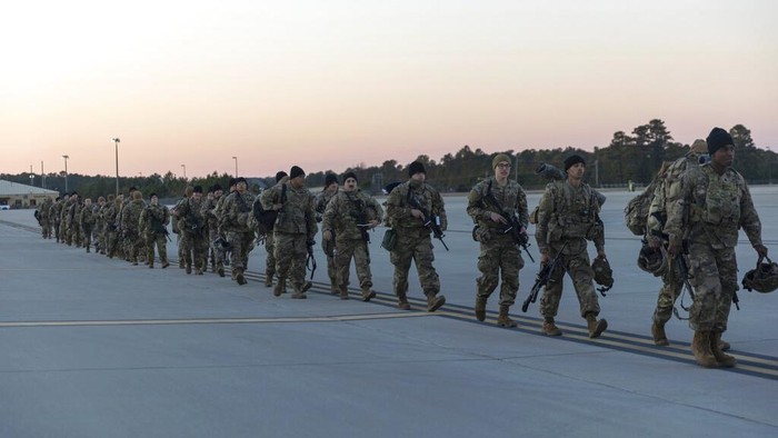 Members of the 82nd Airborne Division of the U.S. Army walk on the tarmac at Pope Field ahead of deployment to Poland from Fort Bragg, N.C. on Monday, Feb. 14, 2022. They are among soldiers the Department of Defense is sending in a demonstration of American commitment to NATO allies worried at the prospect of Russia invading Ukraine.  (AP Photo/Nathan Posner)