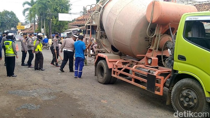 Personel Polres Pekalongan menambal lubang di Jalan Raya Pekalongan-Dieng, Selasa (15/2/2022)