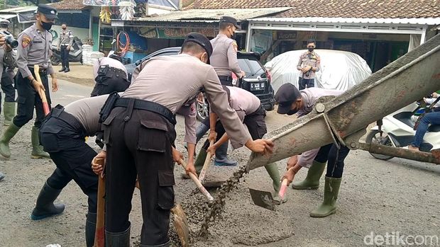 Personel Polres Pekalongan menambal lubang di Jalan Raya Pekalongan-Dieng, Selasa (15/2/2022)