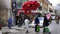 Wanita Afghanistan melewati pedagang kaki lima yang menjual balon merah berbentuk hati selama Hari Valentine, di Kabul, Afghanistan. Di sisi lain, ada kekhawatiran akan masa depan yang tidak pasti karena ekonomi tertatih-tatih. Bahkan situasi di ambang keruntuhan ekonomi. 