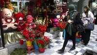 Wanita Afghanistan melewati toko bunga yang didekorasi untuk Hari Valentine di Kabul, Afghanistan. Enam bulan sejak Kabul direbut Taliban dan kaburnya presiden yang didukung AS, penduduk mengatakan ketenangan mulai tercapai.