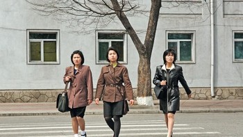 Tiga wanita melintas di jalanan Pyongyang yang sepi, dengan busana seragam. Foto: Hufpost