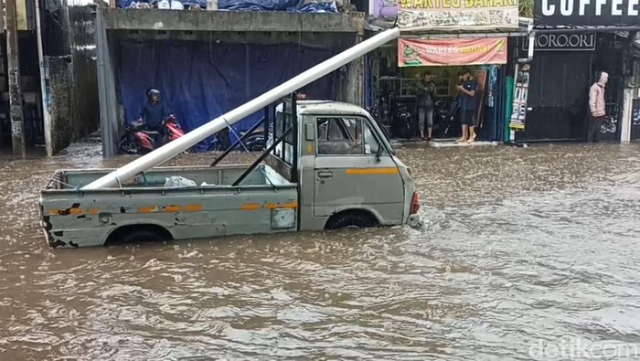 Sebuah mobil pikap terjebak banjir di Jl Kolonel Masturi Cimahi
