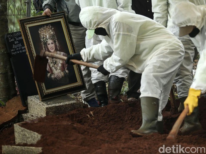 Sejumlah petugas memakamkan jenazah Dorce Gamalama di TPU Bantar Jati, Jakarta Timur, Rabu (16/2/2022). Pemakaman tersebut menggunakan prokes COVID-19.
