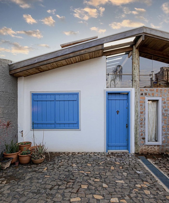 Sepintas, rumah ini terlihat biasa-biasa saja dengan pintu dan jendela kayu berwarna biru. (Foto: Dok: Instagram/Terra e Tuma Arq)