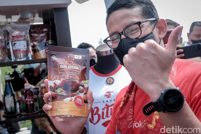 Menteri Pariwisata dan Ekonomi Kreatif Sandiaga Uno tengah memegang kuliner khas Kota Bitung