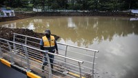 Petugas menyaksikan proses pengairan kolam retensi pengendali banjir di Pasir Kaliki, Cimahi, Jawa Barat, Rabu (16/2/2022).