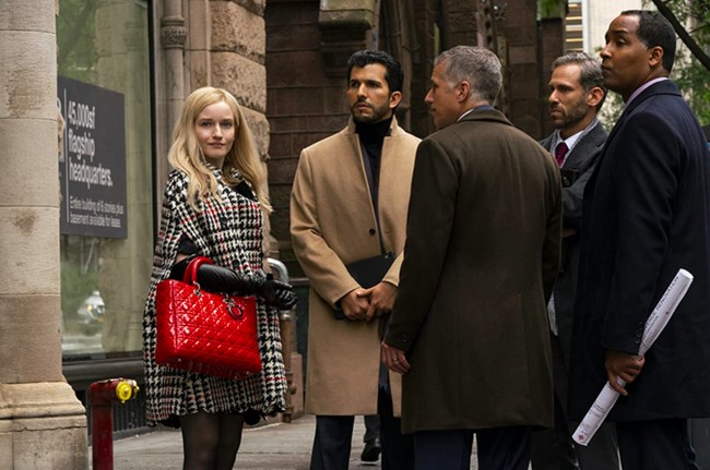 Kostum Inventing Anna ditangani oleh Lyn Paolo dan tim. Kepada Fashionista, ia mengaku menghabiskan waktu tiga bulan untuk melakukan riset soal penampilan karakter Anna Delvey. Koleksi runway dari 2017 dan 2018 menjadi bahan referensi sesuai latar yang diangkat Netflix. Inilah salah satu hasil Lyn dan timnya untuk Anna saat tampil di adegan pencarian lokasi klub. Ponco motif houndstooth dan tas Dior merah mencolok menjadi andalannya. (Foto: Dok. Shondaland/Netflix)