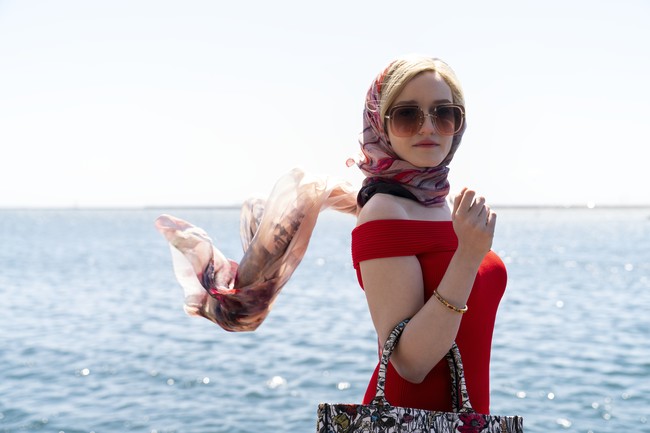 Anna sempat berlibur di Ibiza dengan sang kekasih sekaligus bertemu investor potensial. Sisi chic Anna dipancarkan lewat balutan mini dress warna merah dari label Alexander McQueen, berpadu dengan scarf yang membungkus kepalanya. Tidak ketinggalan Dior Book Tote bermotif bunga. (Foto: Dok. Shondaland/Netflix)