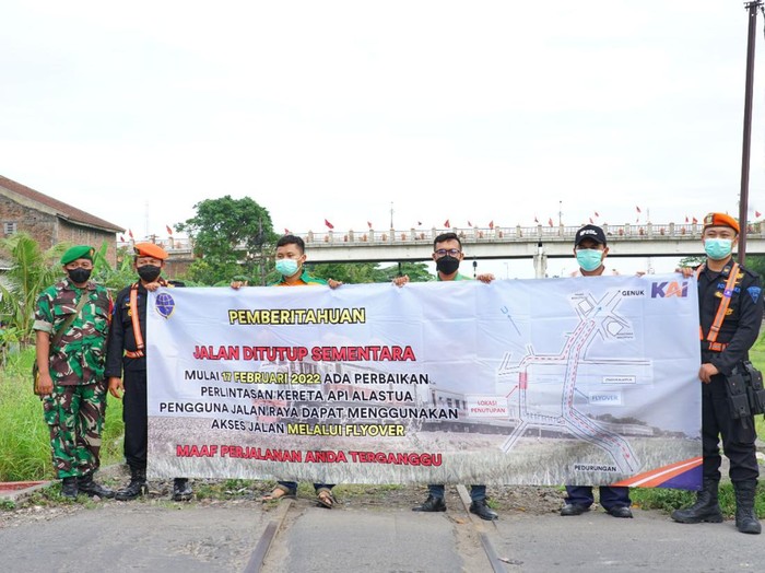 Petugas memberikan sosialisasi penutupan sementara perlintasan rel di Alastua, Semarang.