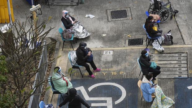 People, including current hospital patients, showing COVID-19 symptoms wait at a temporary holding area outside Caritas Medical Centre in Hong Kong Wednesday, Feb. 16, 2022. China's leader Xi Jinping took a personal interest in Hong Kong's outbreak, saying it was the local government's 