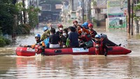 Petugas gabungan dari BPBD dan Tim SAR Kota Bekasi mengevakuasi warga dengan menggunakan perahu karet.
