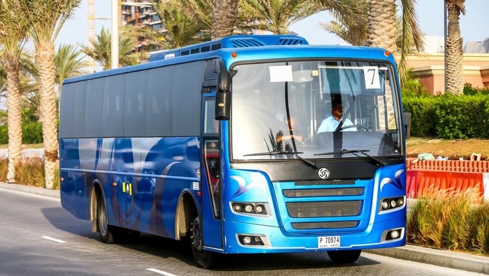 Dubai, UAE - November 16, 2018: Blue coach bus Ashok Leyland Falcon in the city street.