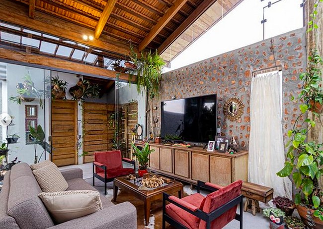 Nuansa villa langsung terasa di ruang tamu dan keluarga. Batu bata dibiarkan terekspos sehingga menciptakan kesan alami. (Foto: Instagram/Terra e Tuma Arq)
