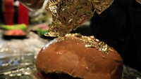 Omar Makram (30), pemilik restoran Fasakhanesta, menggunakan daun emas saat ia menyiapkan burger feseekh.