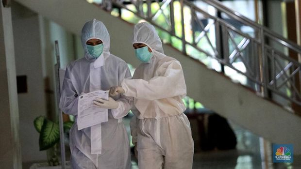 Tenaga medis mengantar pasien dengan ambulance saat tiba di Graha Wisata TMII, Jakarta, Kamis, 17/2. Jakarta jadi salah satu daerah yang mencatatkan kenaikan kasus COVID-19.(CNBC Indonesia/ Muhammad Sabki)