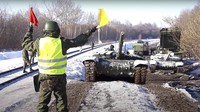 Dalam foto yang diambil dari video yang disediakan oleh Layanan Pers Kementerian Pertahanan Rusia, Rabu, (16/2/2022), tank tentara Rusia dimuat ke platform kereta api untuk kembali ke pangkalan mereka.