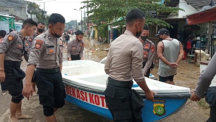 Polisi evakuasi warga kebanjiran di Perumahan Pondok Gede Permai, Bekasi (Fakhri/detikcom)