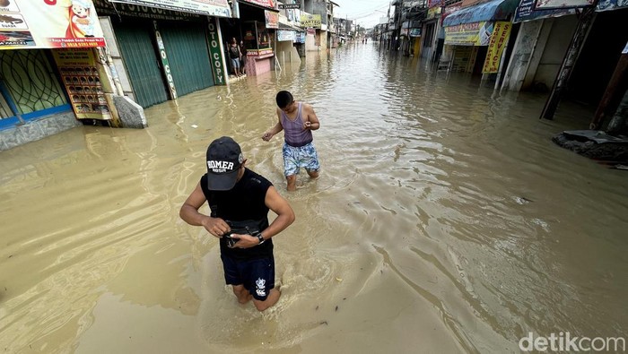 Potret Warga Bekasi Beraktivitas di Tengah Banjir Banjir merendam area perumahan Pondok Gede Permai (PGP), Kota Bekasi. Diketahui, banjir terjadi akibat meluapnya Kali Bekasi. Ini penampakannya.