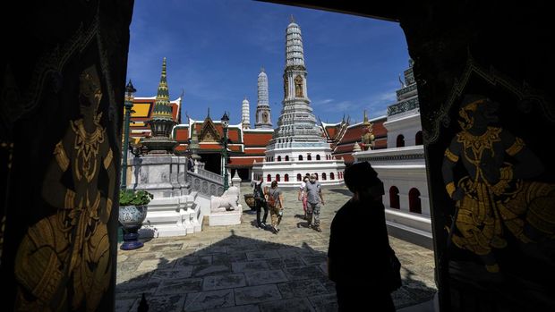 FILE - Tourists visit Grand Palace in Bangkok, Thailand, on Nov. 29, 2021. Thailand on Tuesday, Dec. 21, 2021, decided to immediately restore a mandatory quarantine for visitors and suspend a “test-and-go” scheme for fully vaccinated arrivals as concerns grew over the spread of the COVID-19's omicron variant, the government said. (AP Photo/Sakchai Lalit, File)