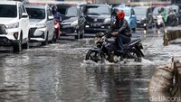Genangan air yang ada di kawasan HR Rasuna Said membuat para pengendara, khususnya pengendara motor memelankan kendaraannya saat melintasi jalan tersebut.