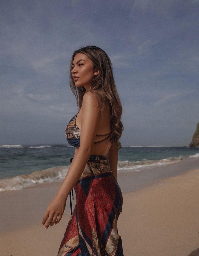 Berjalan di tepi pantai, Ariel Tatum tampil menawan mengenakan atasan bikini yang dipadukan dengan celana panjang bahan dengan motif yang sama. Busana yang dikenakannya itu tampak jelas memperlihatkan bentuk tubuhnya yang langsing. Foto: dok. Instagram/@arieltatum